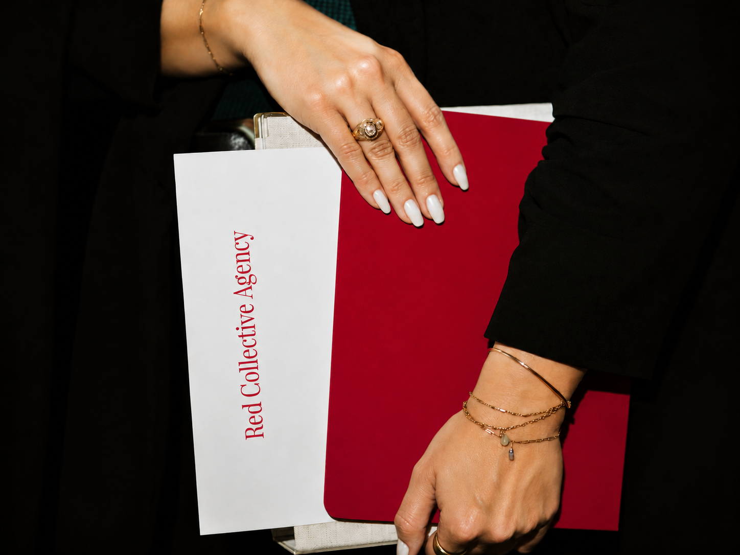 Hands holding Red Collective Agency brand folder
